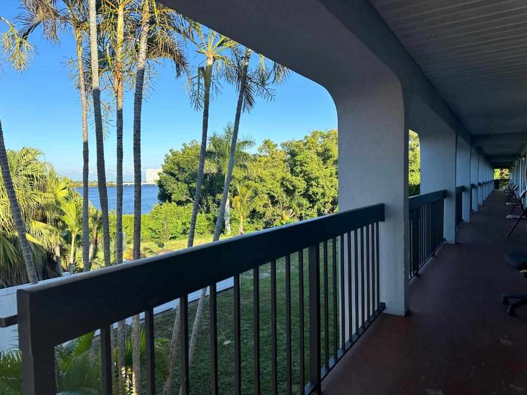 Balcony walkway with palm trees and river view at Riverview Inn